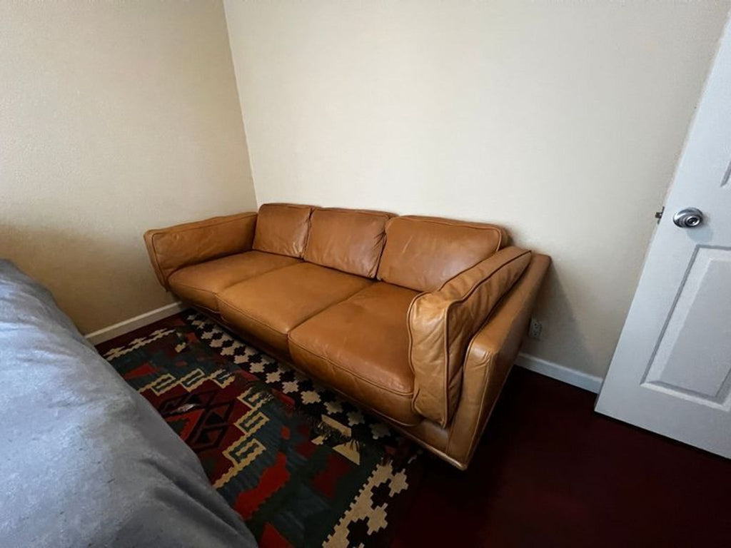 Leather Article 3-seater sofa against a corner wall, next to a partially open door.