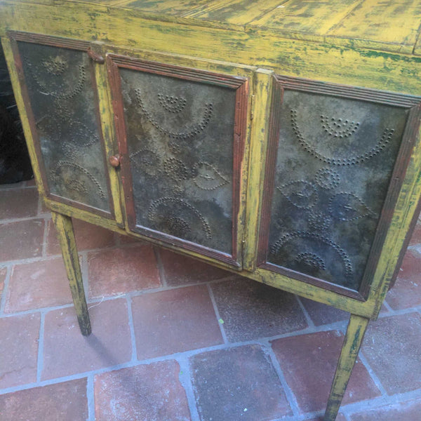 1. Distressed yellow cabinet with three punched metal doors, featuring rustic wood frame and decorative patterns.