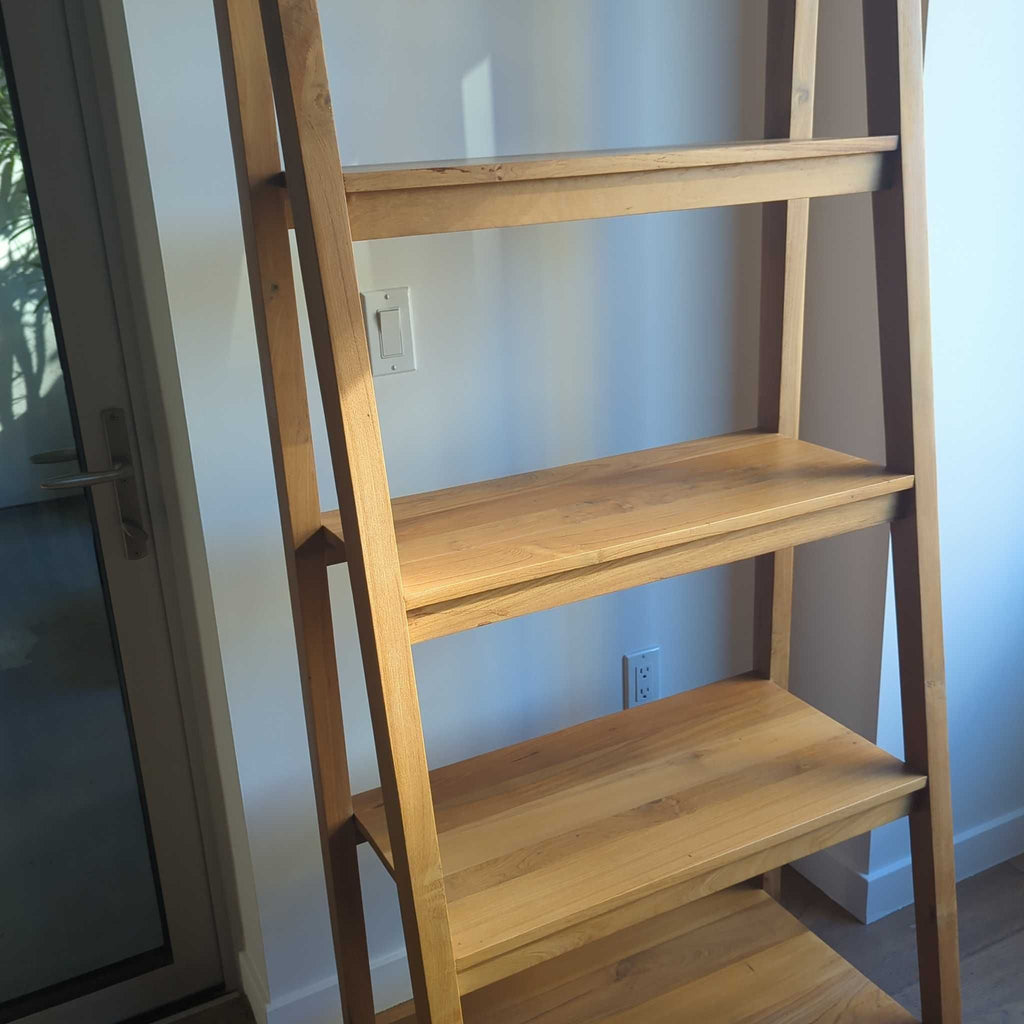 1. Modern wooden bookshelf with open shelves holding books and decorative items.  