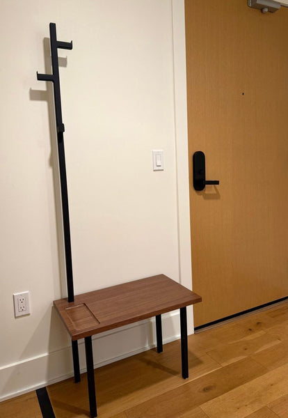 1. Modern entryway bench by Room & Board with a wooden seat, black legs, and a built-in coat rack.