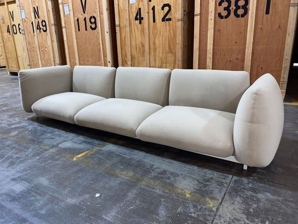 Paola Lenti Mellow sectional sofa in modern design, upholstered in textured fabric, shown in a living space.