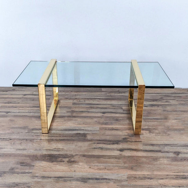 a coffee table with a glass top and a gold frame.