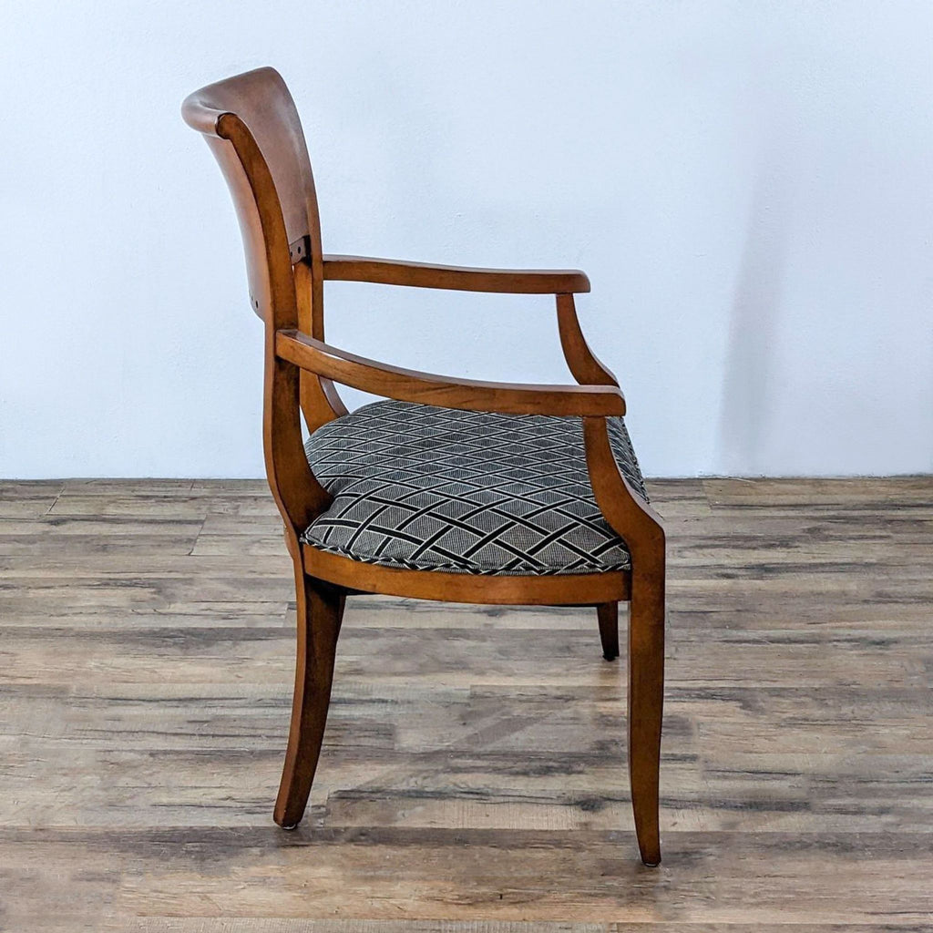 Side view of a neoclassical chair with wood frame and patterned seat.  