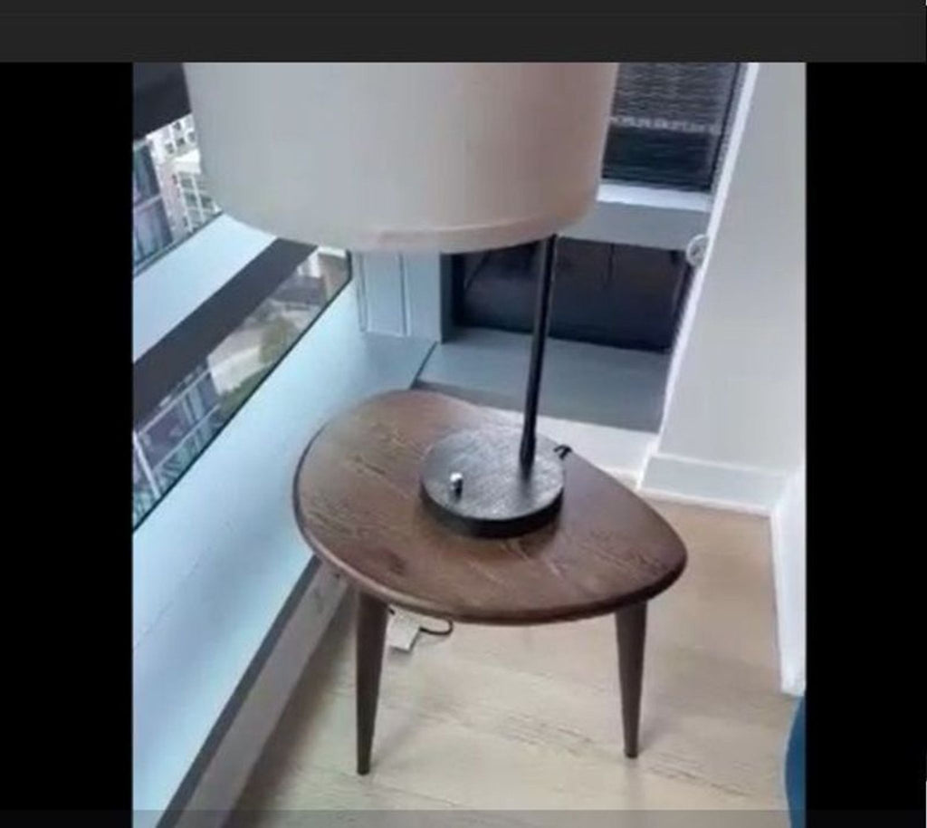 1. Teardrop-shaped wooden side table in good condition, placed by a window with a lamp on top.