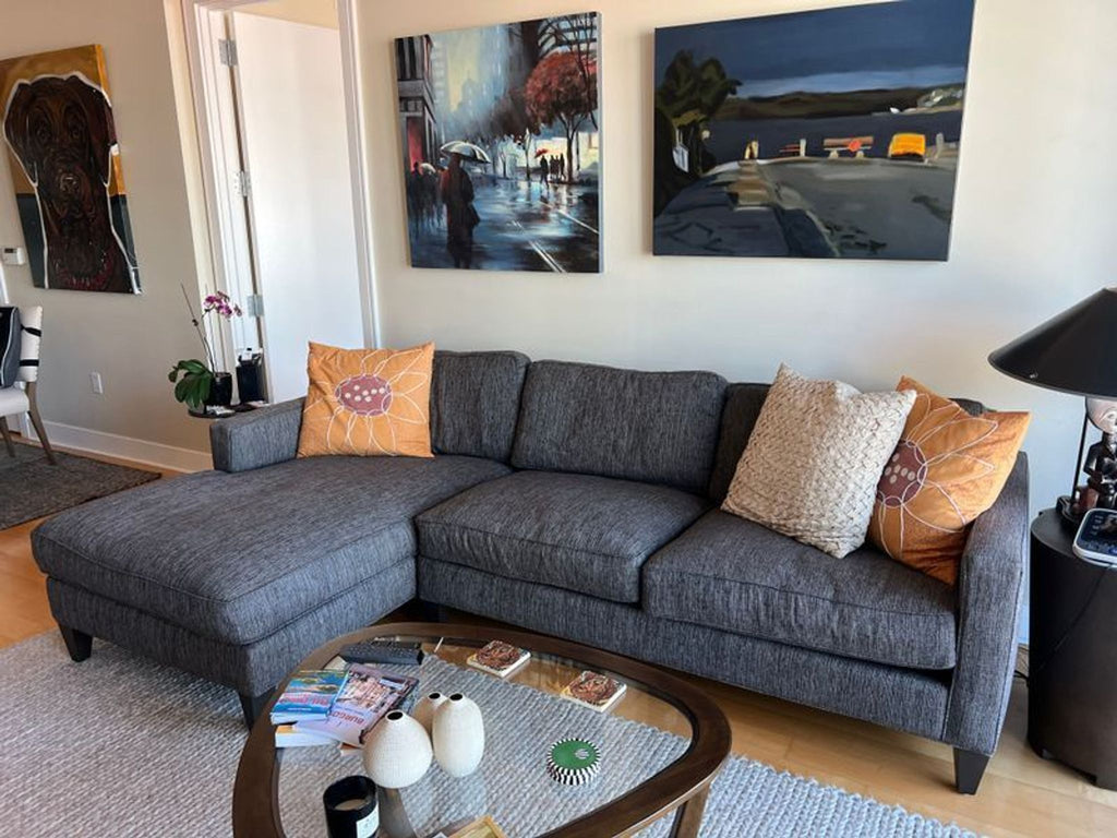 1. Gray Room and Board sectional with chaise in a living room, decorated with orange and cream pillows.