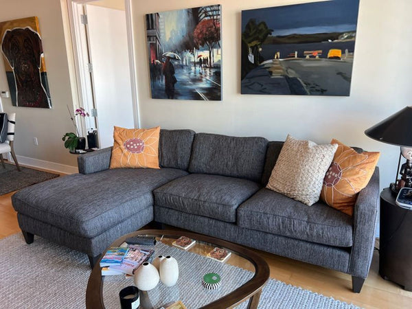 1. Gray Room and Board sectional with chaise in a living room, decorated with orange and cream pillows.