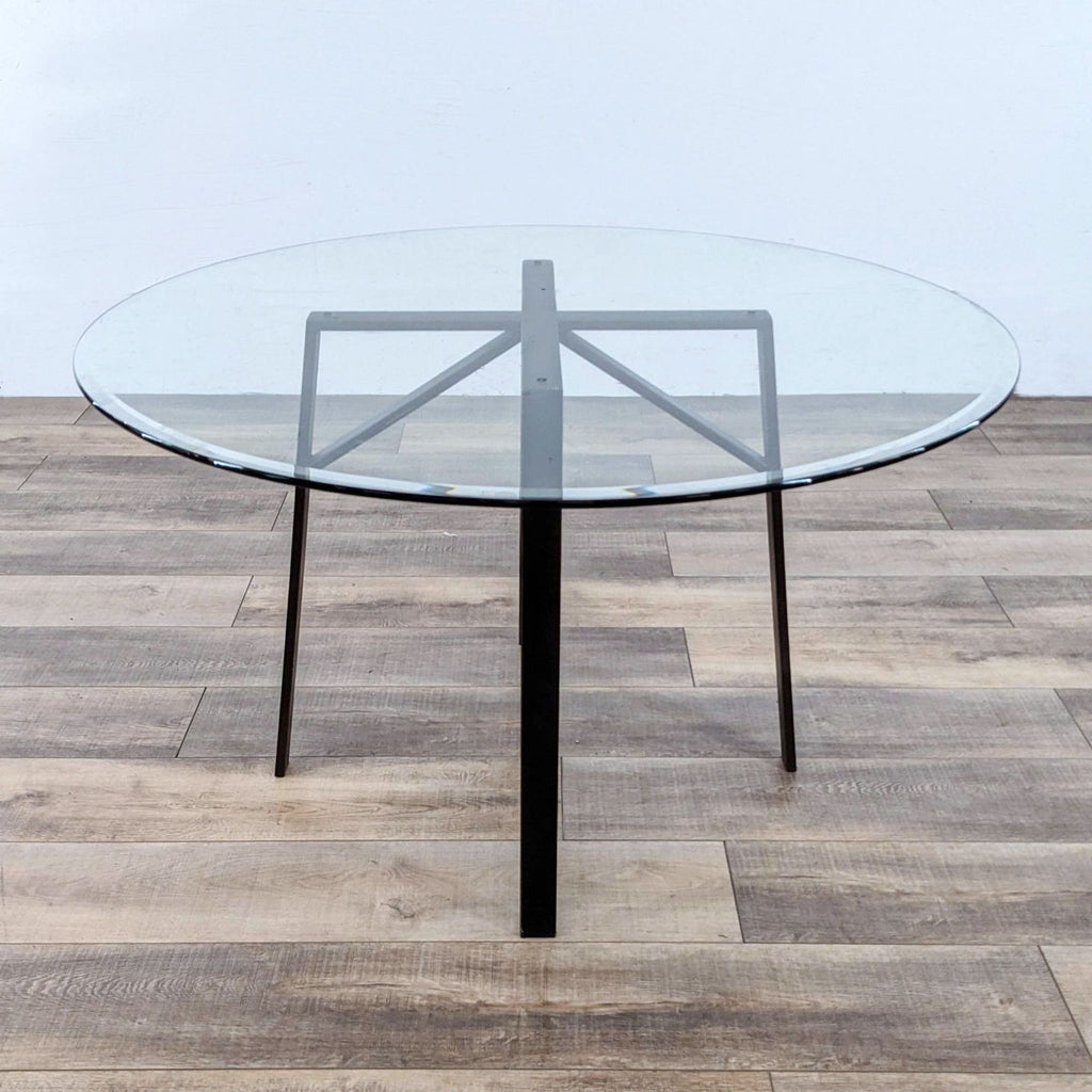 a round table with a glass top and a black metal base.