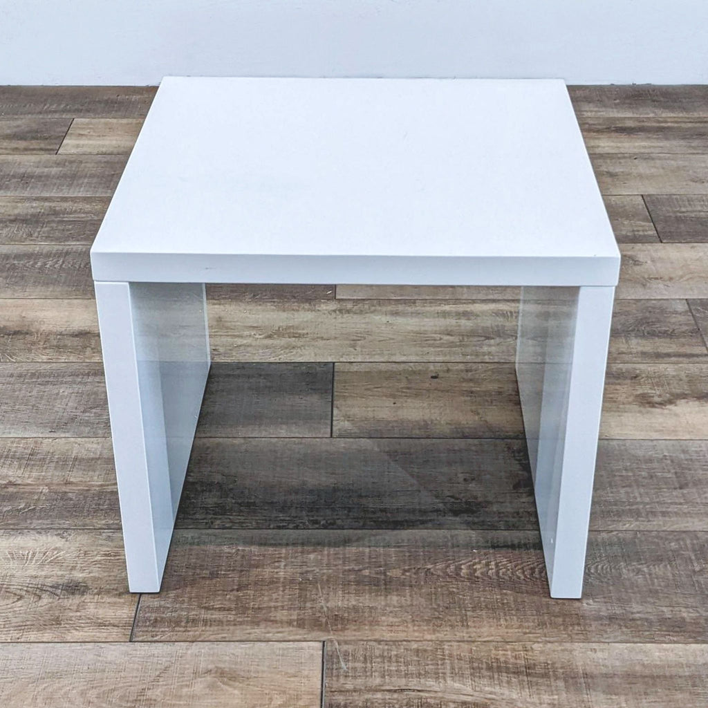 White end table by Reperch, modern style, on a wooden surface.  