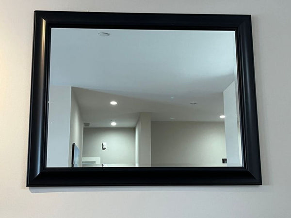 1. Pair of large framed mirrors displayed side by side, reflecting a modern, well-lit room.