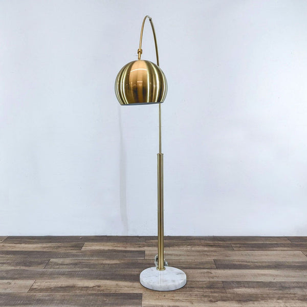 Reperch floor lamp with golden shade and marble base.
