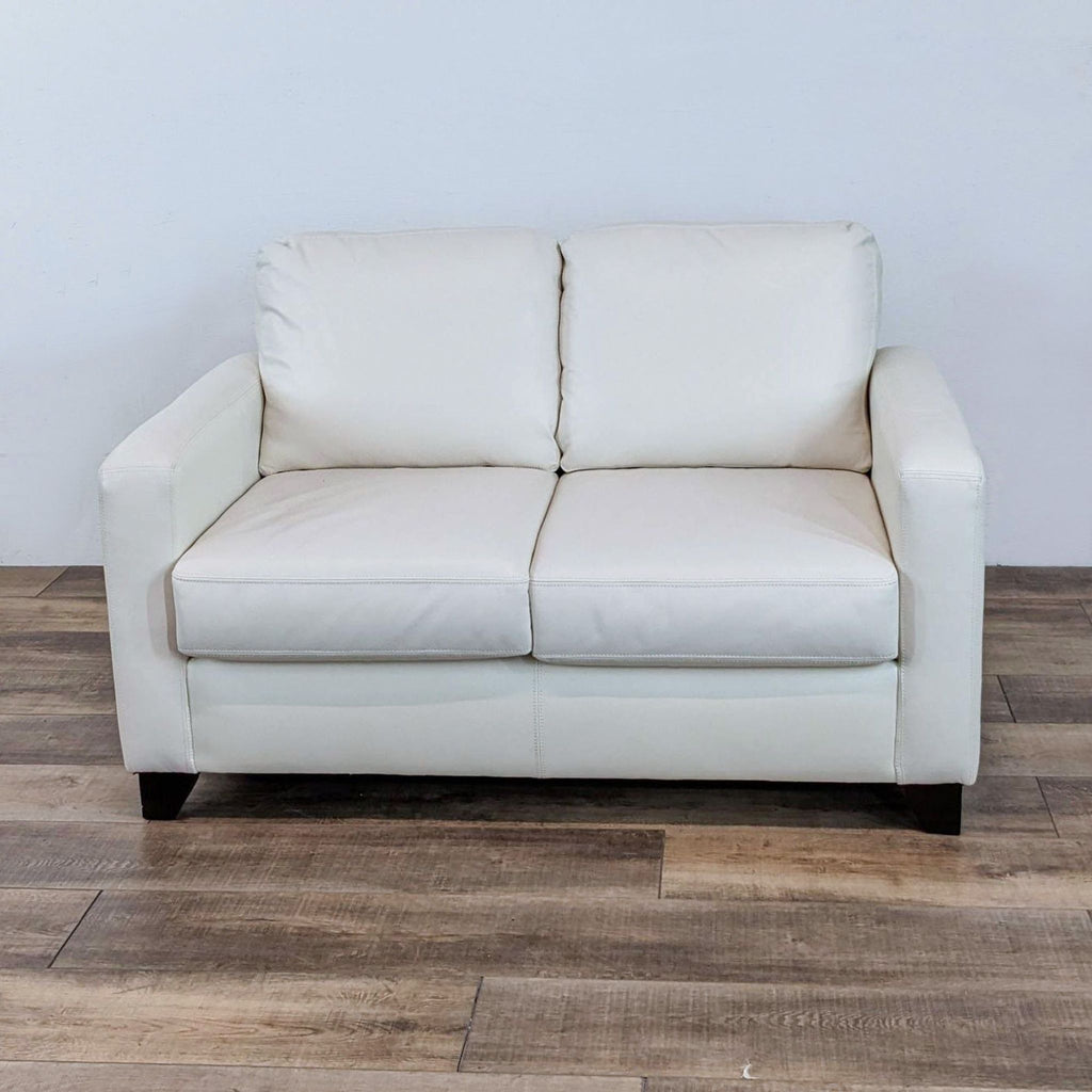1. Front view of a contemporary white loveseat with clean lines, track arms, and dark finish feet by Sofa By Fancy.