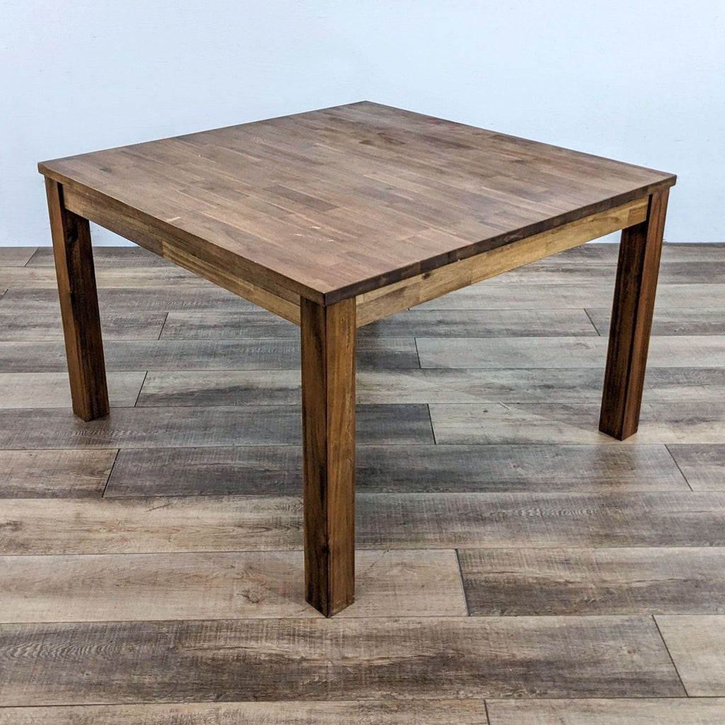 Square dining table featuring straight block legs and an amber-stained top.