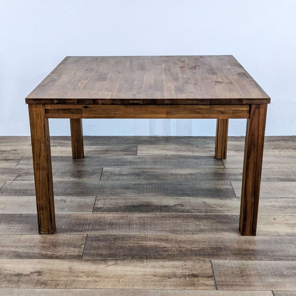 Reperch dining table with a butcher block top and amber finish.