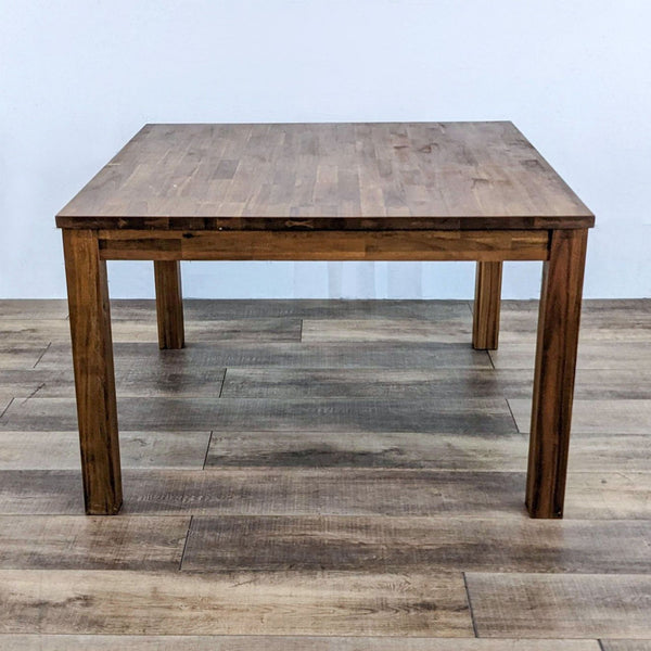 Reperch dining table with a butcher block top and amber finish.