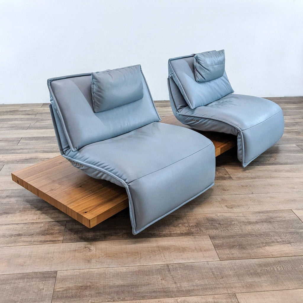 Side view of blue lounge chairs with pillows on wooden platform, by Koinor.