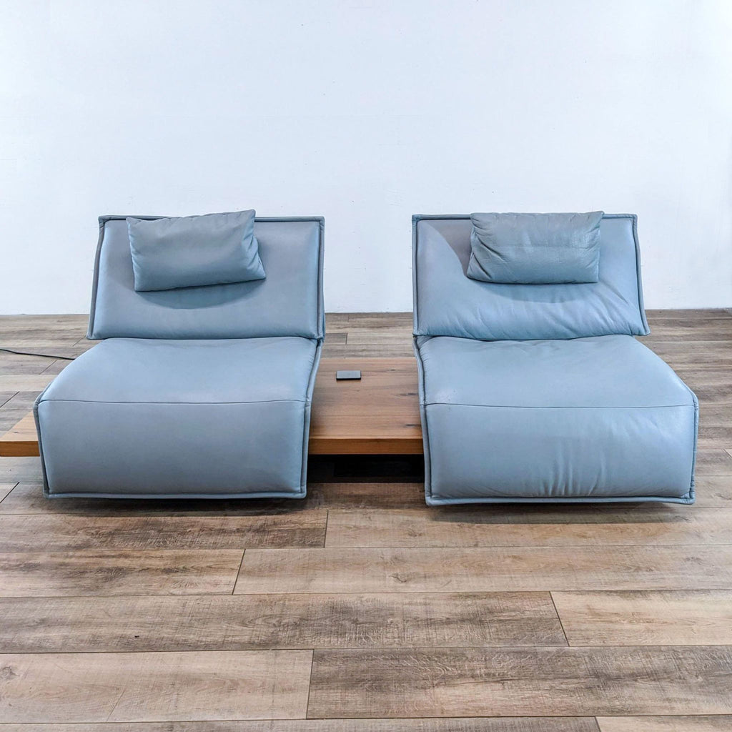 Blue twin lounge chairs with pillows on a wooden base, by Koinor.