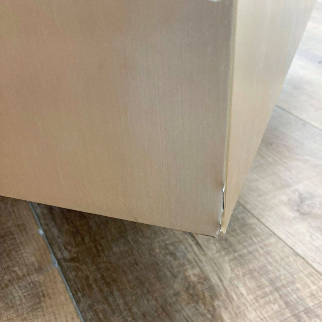3. Detail of a Mobital coffee table's lower corner, highlighting a dent and finish imperfection on brushed steel.
