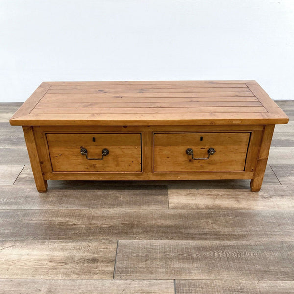 Solid wood coffee table with two drawers, showcased on wooden flooring.