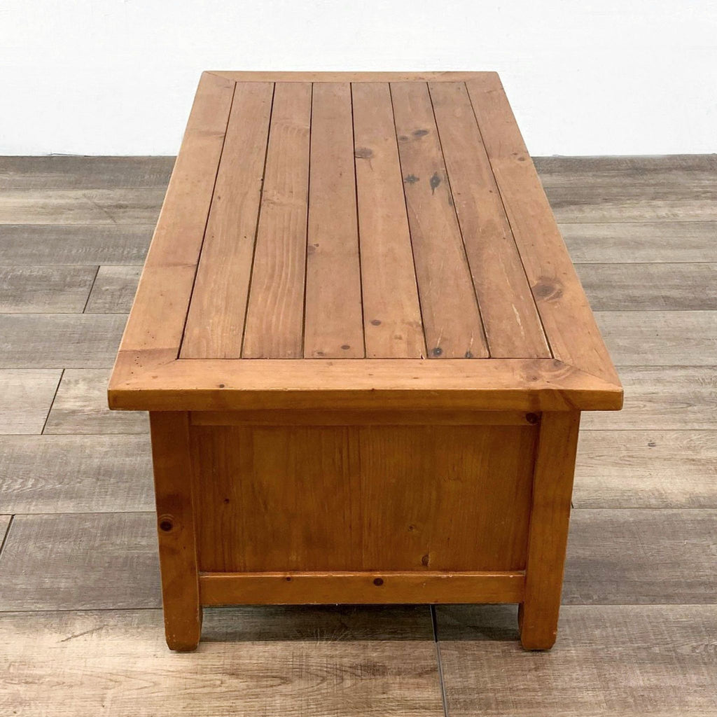Side view of the wooden coffee table highlighting its sleek, slatted top.