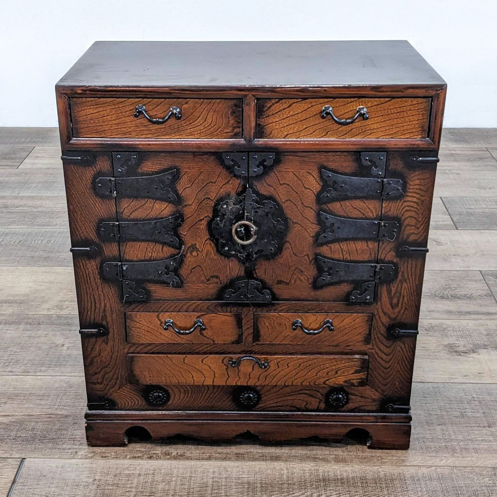 Reperch end table with drawers and ornate metal accents.