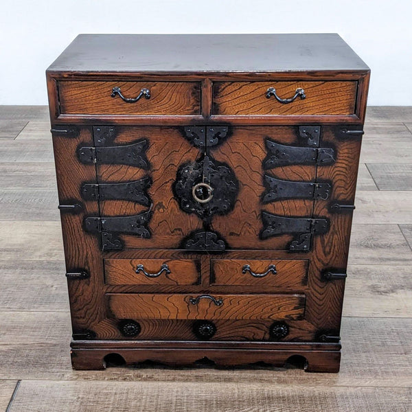 Reperch end table with drawers and ornate metal accents.