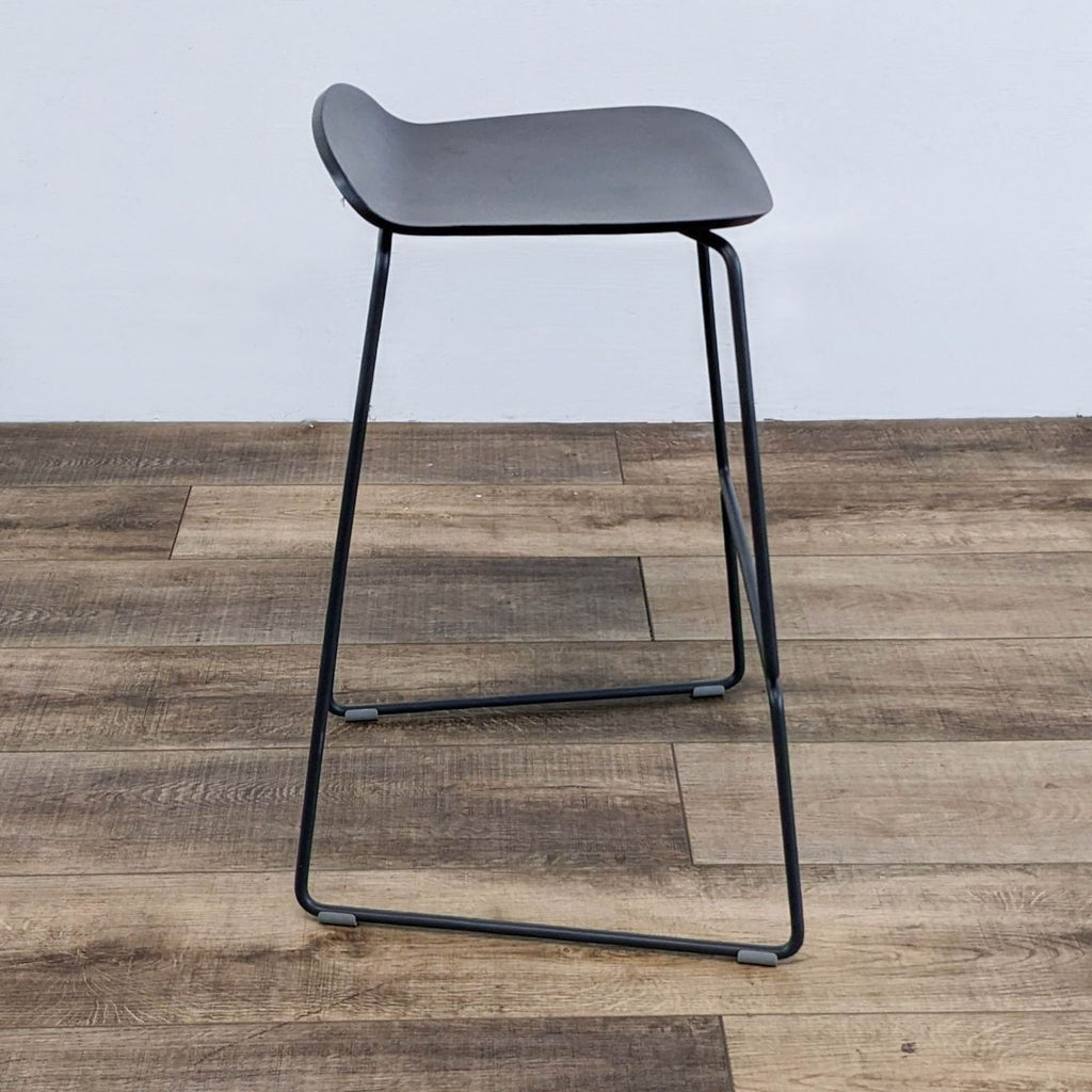 the stool is made of a black steel frame and is made of a black steel frame.