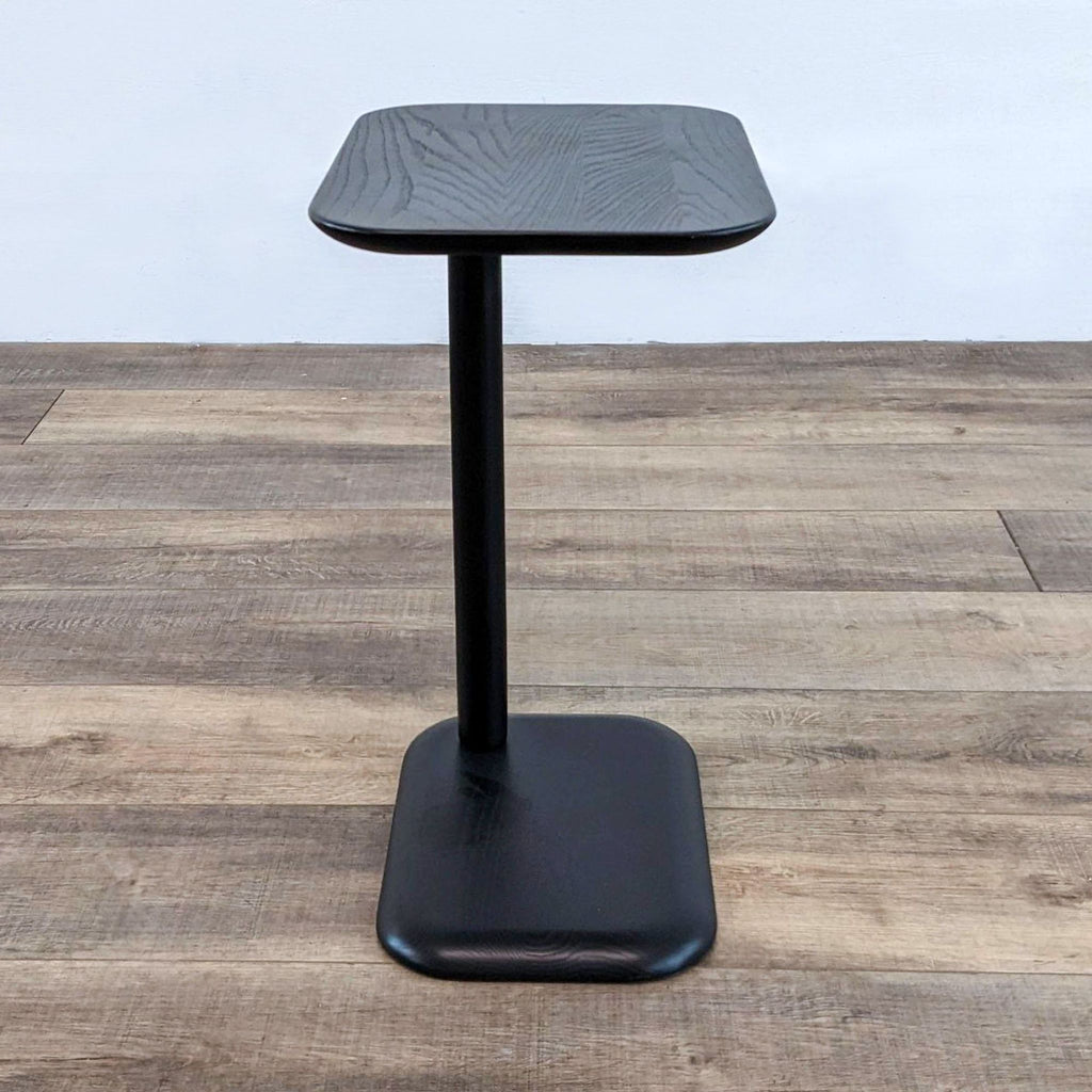 Black ash console table with sleek design and rounded edges.