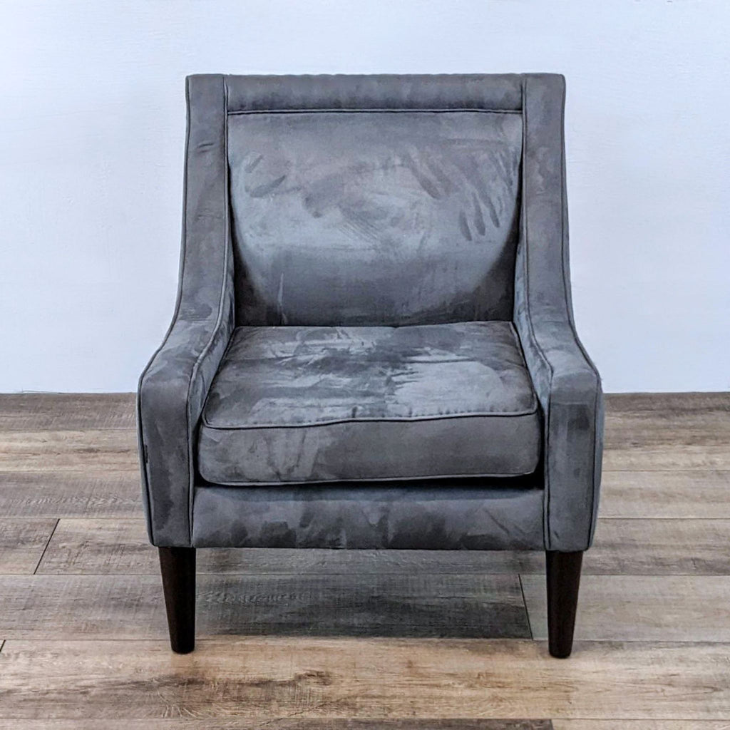 Front view of a gray armchair with plush cushion and tapered wood legs.