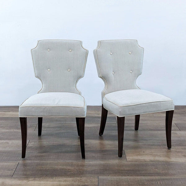 Pair of Oliixx dining chairs with button tufted backs and wood legs.  