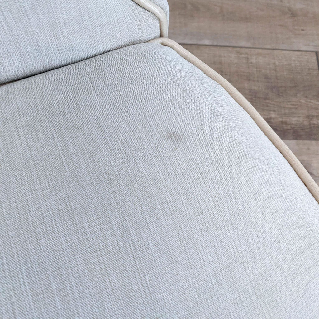Close-up of the Oliixx chair's upholstery and welted trim detail.  