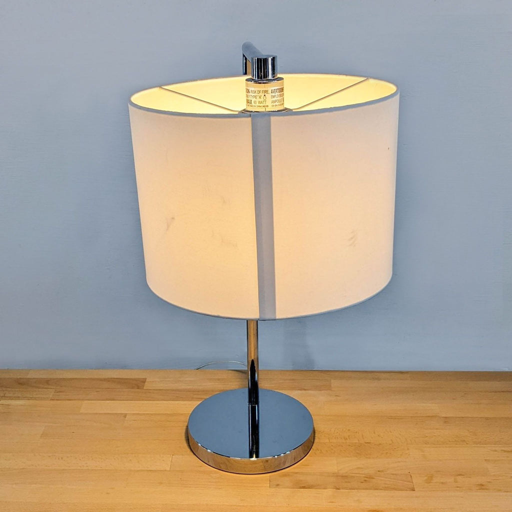 2. Contemporary lamp featuring a shiny chrome base paired with a classic drum shade.