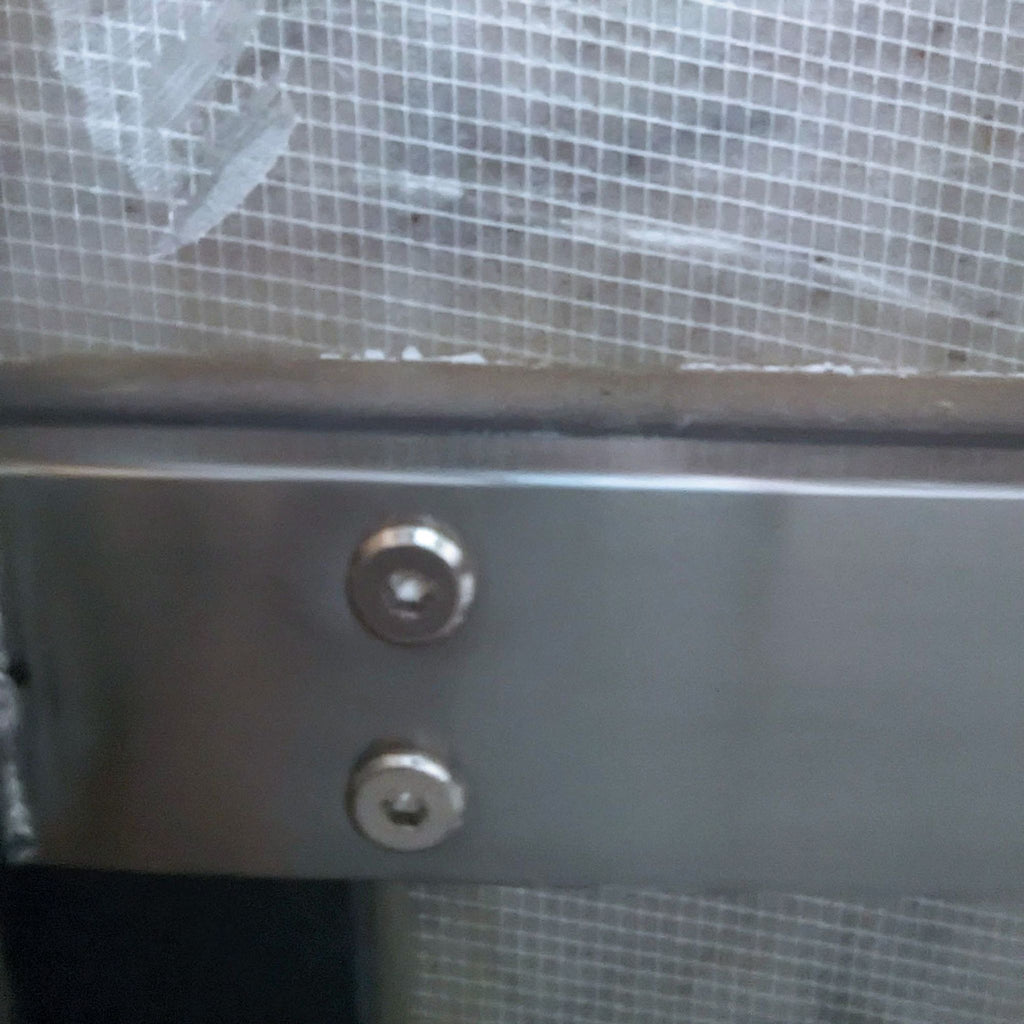 Close-up of metal screws on a metallic structure.