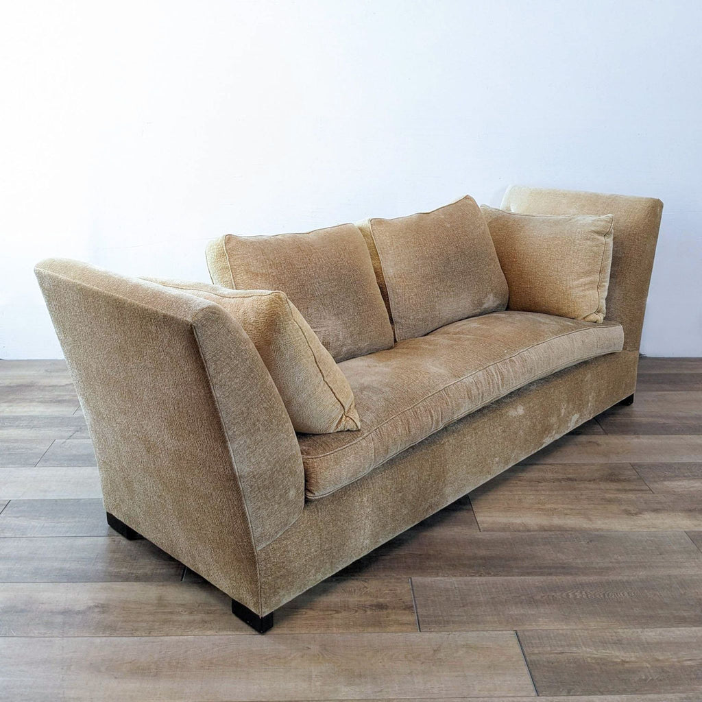 Side view of a beige daybed featuring slant arms and plush pillows.  