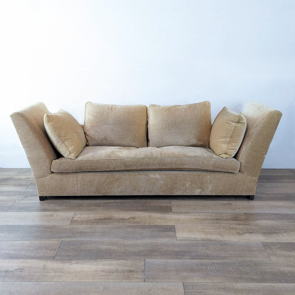 Luxurious beige daybed with a low curved back and loose cushions.  