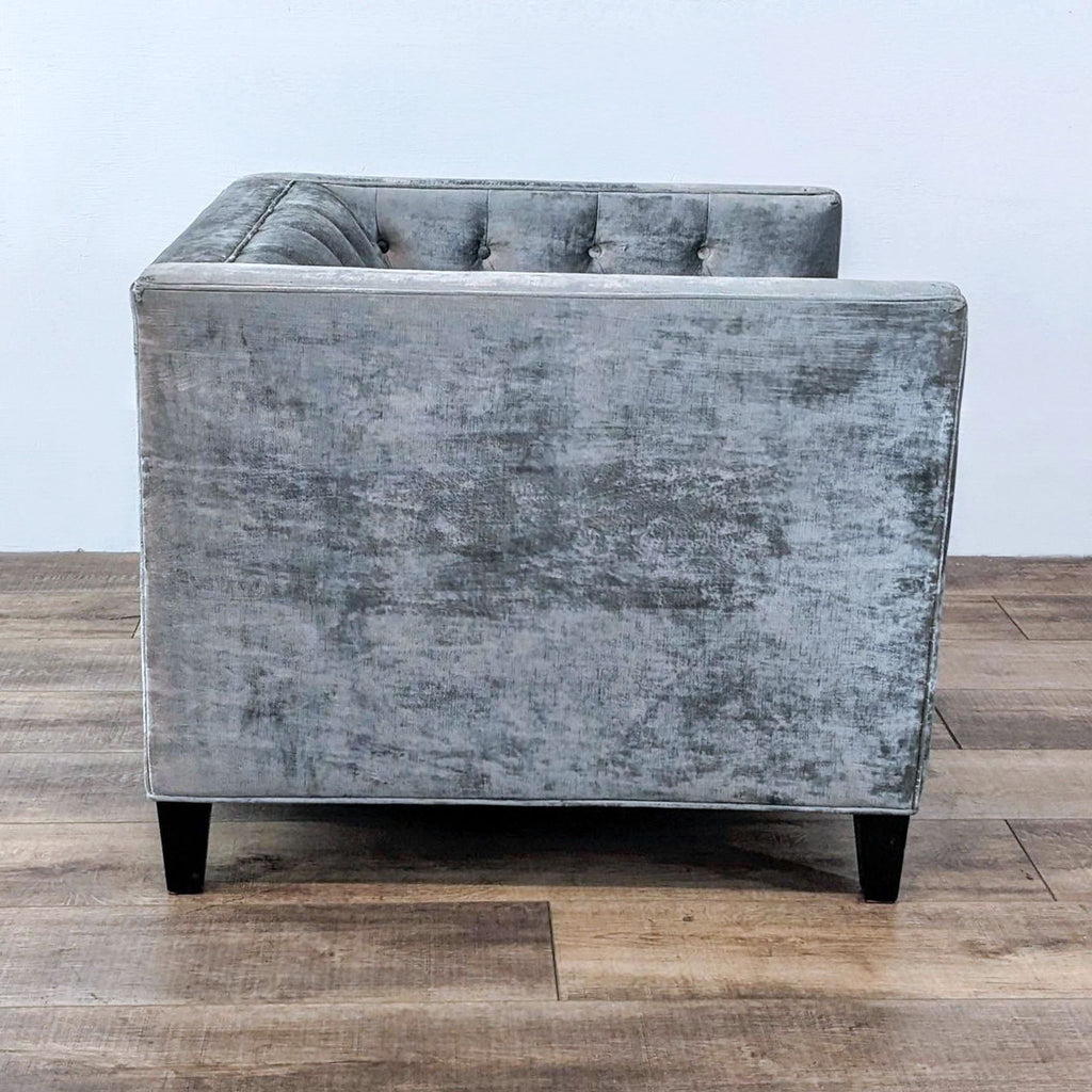Side view of Reperch fabric armchair with button tufting.