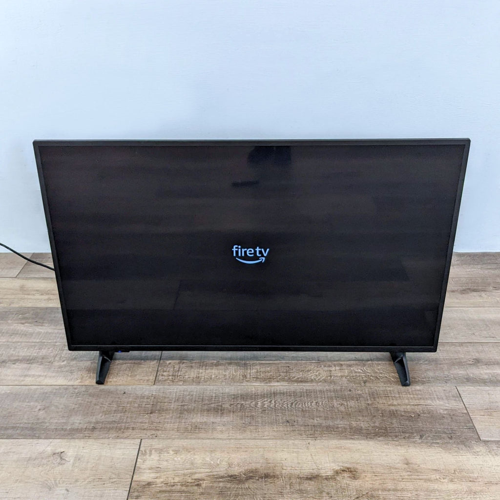 Fire TV Edition in dark mode on a wooden floor.