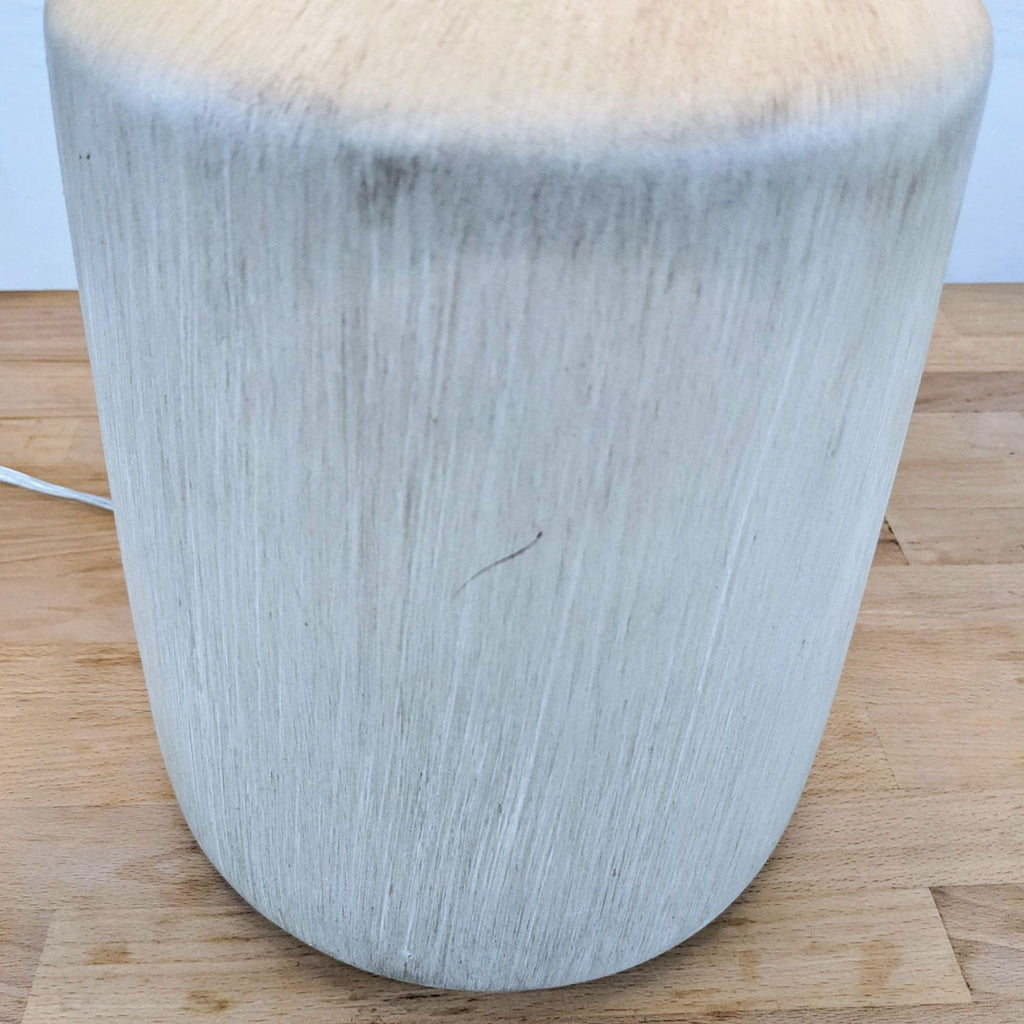 Close-up of the lamp's textured concrete base on the table.