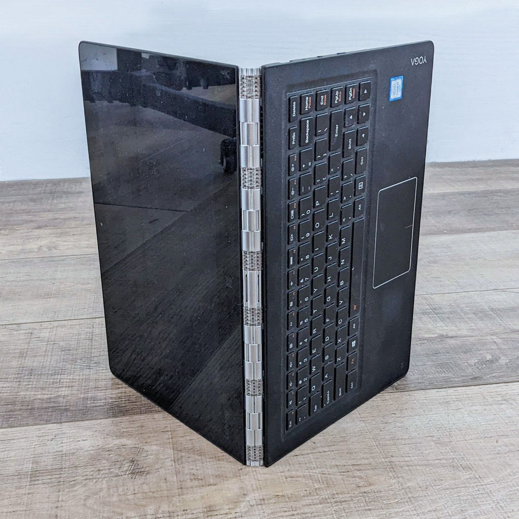 a laptop computer sitting on top of a wooden table 