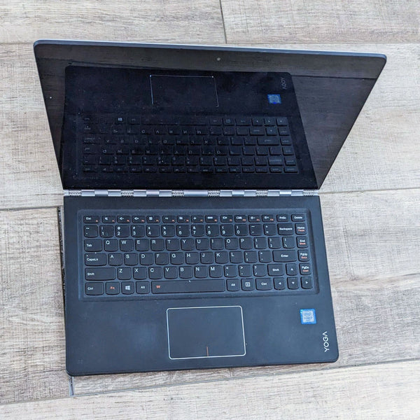 a laptop computer sitting on a wooden table 