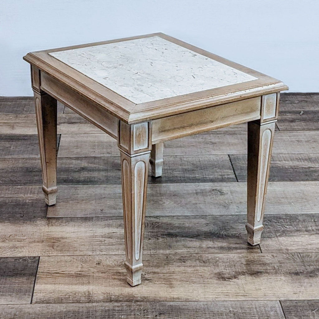 Single Reperch end table featuring a marble top and elegant legs.