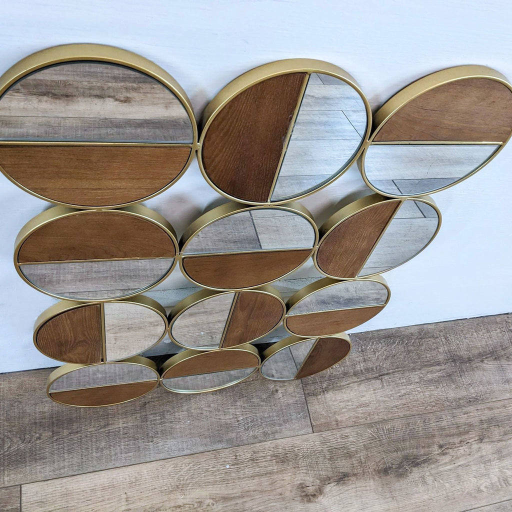 2. Angled view of Zuo Modern Cycle Mirror, showing gold-framed, half wood, half mirrored circular panels.