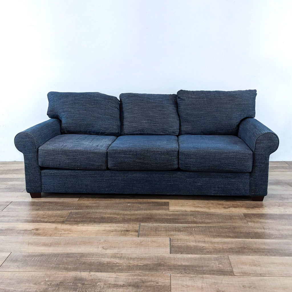 Front view of a blue 3-seat sofa with rolled arms and wood finish feet.