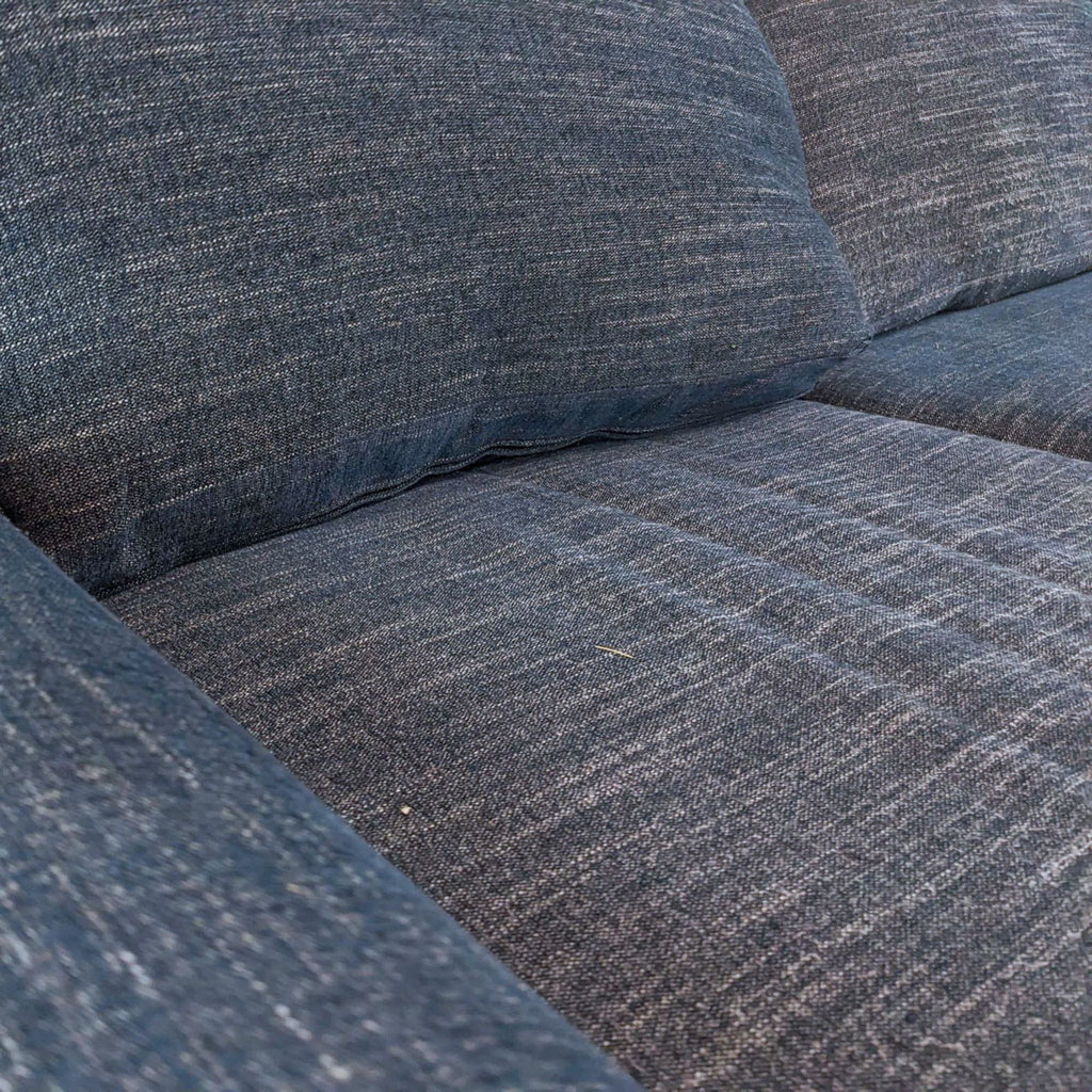Close-up of textured blue fabric cushioning on a 3-seat sofa.