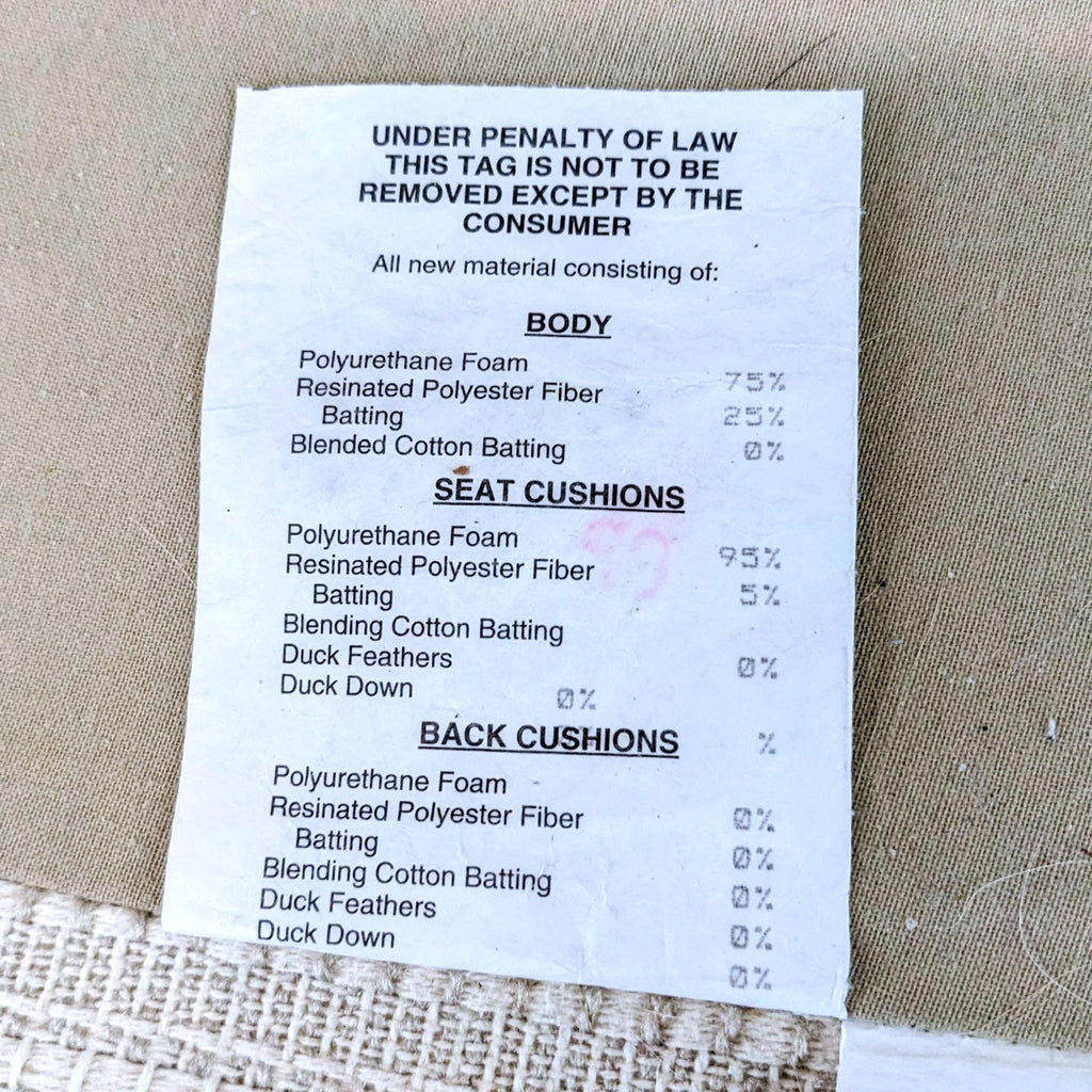 Close-up of tag listing filling materials for body and cushions of Reperch rounded arm off-white fabric loveseat.