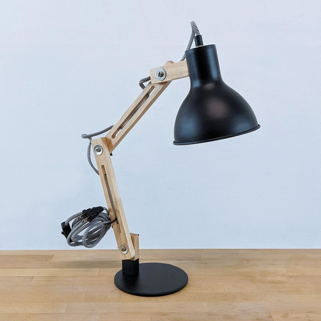 Modern desk lamp with articulating wooden arm and black metal shade.