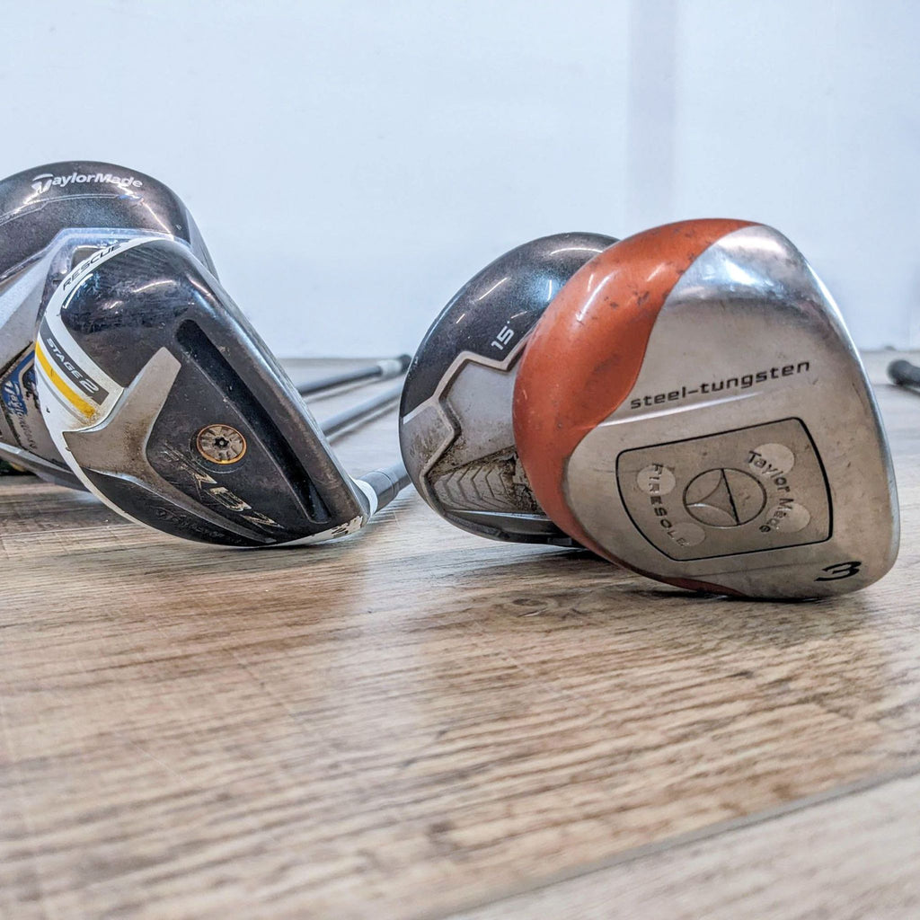 Reperch golf clubs with steel-tungsten heads on wooden floor.