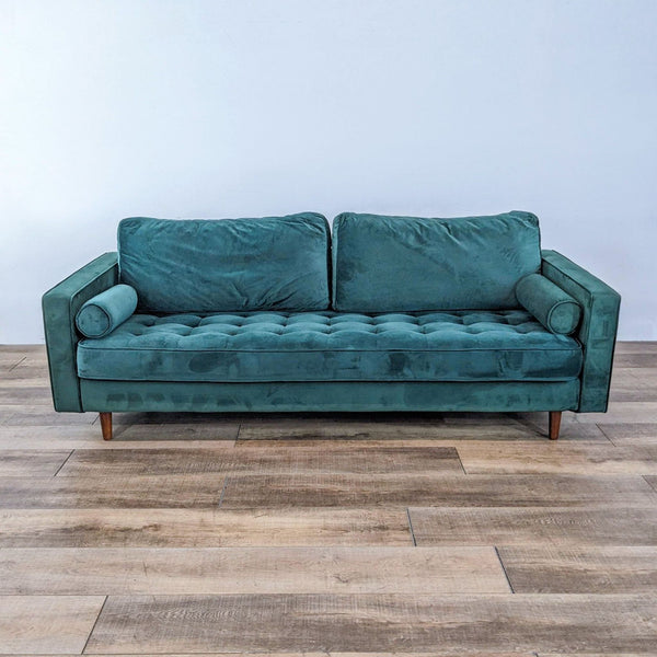 Low profile green tufted sofa with track arms, tapered legs, and two bolster pillows.