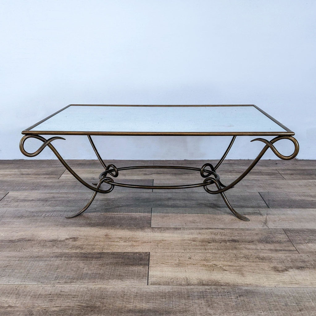 Reperch coffee table with bronze wrought iron base and glass top on wooden floor.