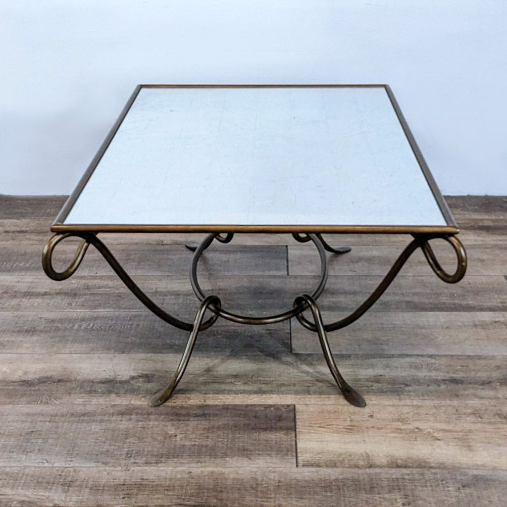 Elegant coffee table by Reperch featuring a bronze-finished wrought iron base and glass top.