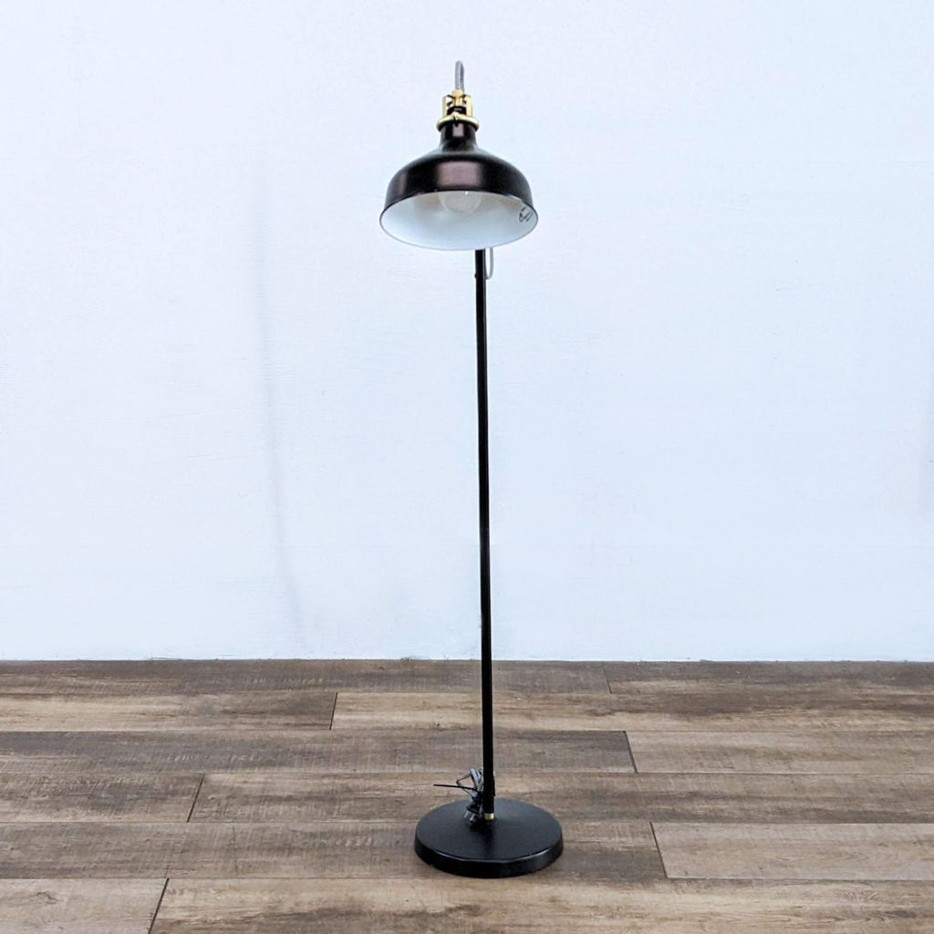 Tall black lamp featuring a dome-shaped shade and sturdy base.